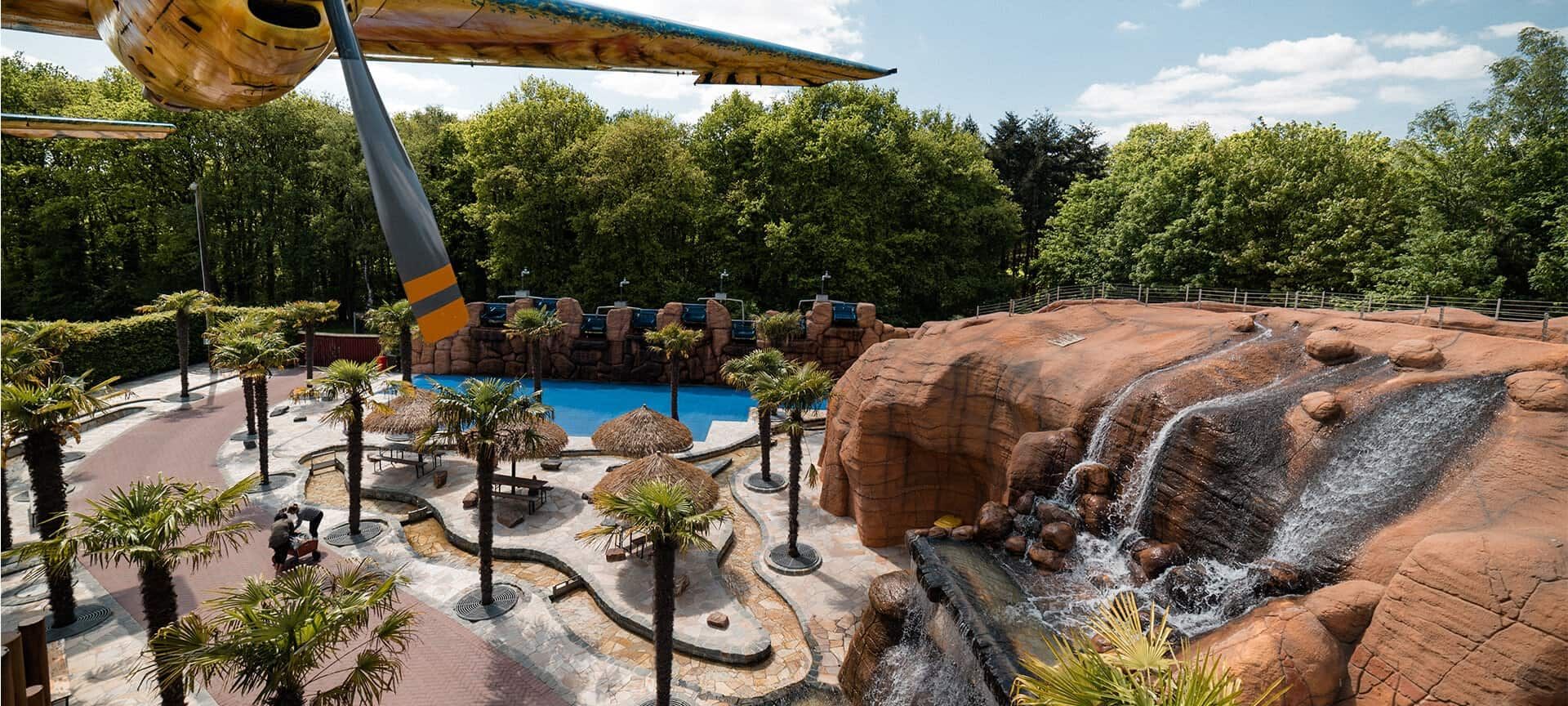Speeltuin met palmbomen, rotsen en een waterval in Irrland