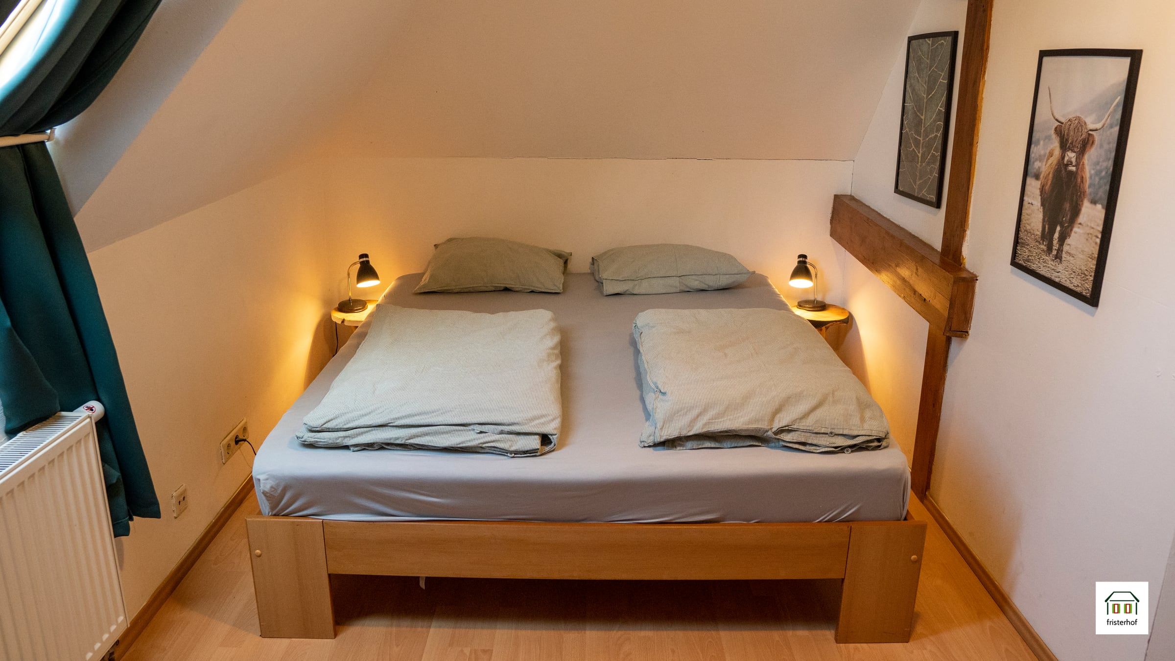 Doppelbett unter der Dachschräge mit Holzbalken